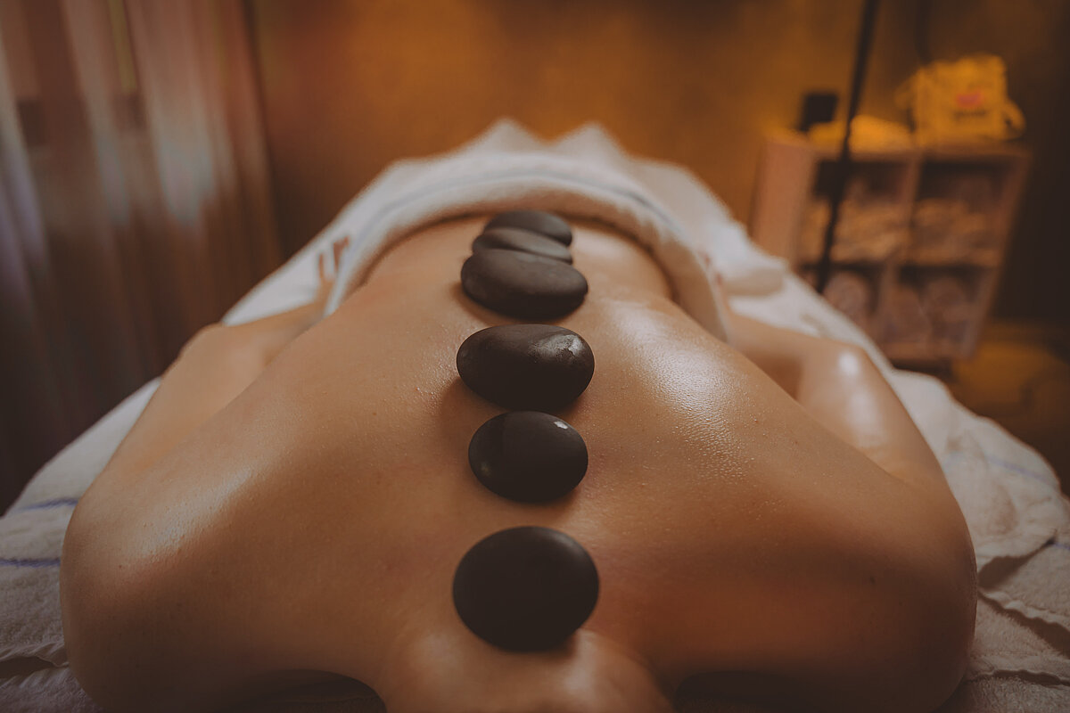 Rueckenmassage mit Massagesteinen