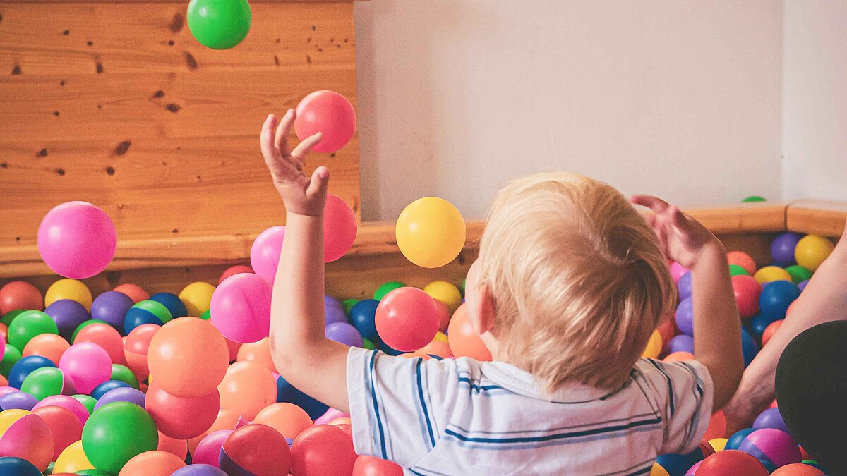 Spielendes Kind im bunten Baellebad.