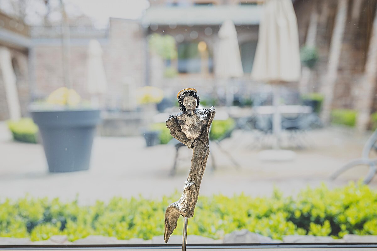 Kunstfigur vor Fenster zum Kreuzgarten